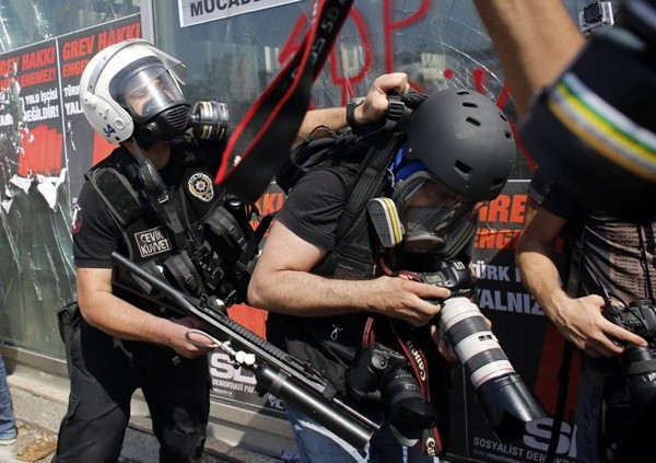  Cảnh sát dẹp loạn ở Thổ Nhĩ Kỳ đang đẩy ngã một người chụp ảnh trong một cuộc biểu tình ở Quảng trường Taksim, Istanbul vào ngày 11/6/2013.