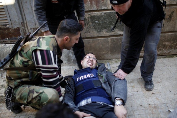  Ayman al-Sahili, một phóng viên ảnh của Reuters, đau đớn khi bị một tay súng bắn tỉa trung thành với Tổng thống Bashar al-Assad bắn trúng vào chân trong lúc đang ghi hình tại tuyến đầu ở thành phố Aleppo, phía Bắc Syria vào ngày 31/12/2012.