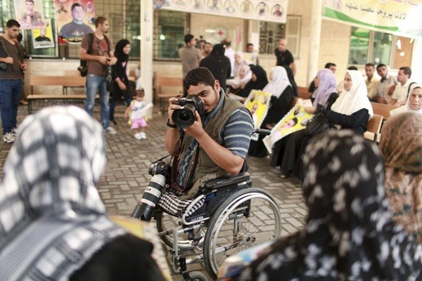  Nhiếp ảnh gia tự do Moamen Qreiqea đang ngồi trên xe lăn để ghi lại hình ảnh của những người biểu tình kêu gọi thả tự do cho các tù binh Palestine khỏi các nhà tù Isreal ở thành phố Gâz vào ngày 1/10/2012.