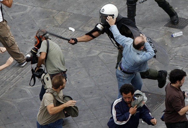  Cảnh sát đánh lại phóng viên tin tức của tờ AFP, ông Panagiotis Tzamaros trong cuộc biểu tình tại Quảng trường Syntagma ở Athens vào ngày 5/10/2011.