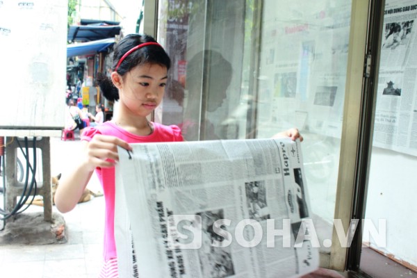  Từ ngày cô cháu ngoại được nghỉ hè, bà Mai có cô bé đồng hành dán báo lên bảng tin của phường mỗi sáng.