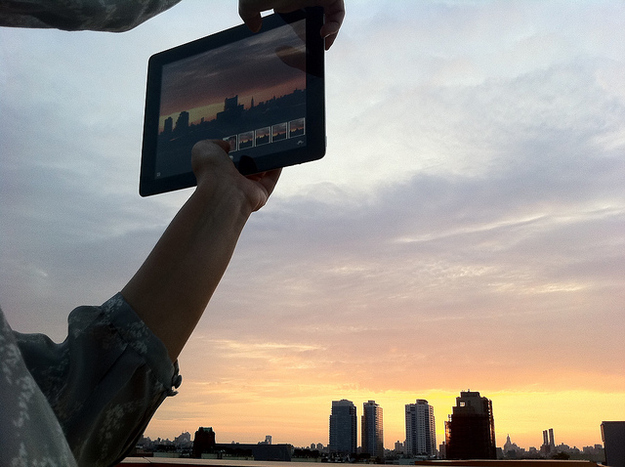 This picture of a young man viewing the sunset the way it was meant to be viewed — through a tiny screen: