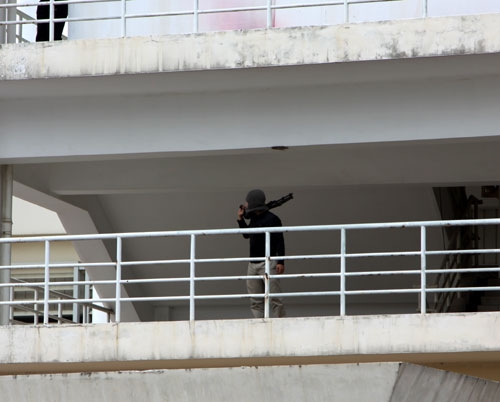 Một tên khủng bố làm nhiệm vụ cảnh giới tại tòa nhà chúng chiếm giữ.