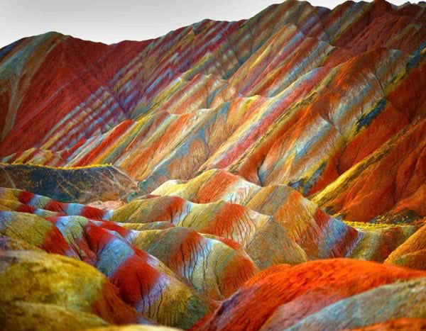 Nhiều người sẽ không tin dãy núi đầy sắc màu trong ảnh tồn tại, nhưng nó đang hiện diện ở. Công viên Địa chất Zhangye Danxia, tỉnh Cam Túc, Trung Quốc. Nó hình thành do qua trình nén các lớp sa thạch và khoáng chất nhiều màu trong suốt 24 triệu năm. Gió và mưa tiếp tục hoàn thành công việc tạo hình cho các núi đá, khiến chúng có nhiều hình dạng khác nhau như cột, thung lũng, khe núi, thác nước.