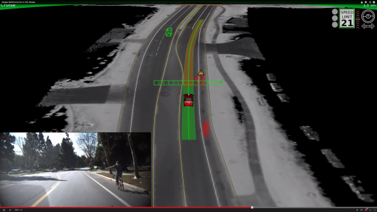 Tự xe lái xe của Google chờ đợi cho một tay đua xe đạp đang tạo ra một tín hiệu tay