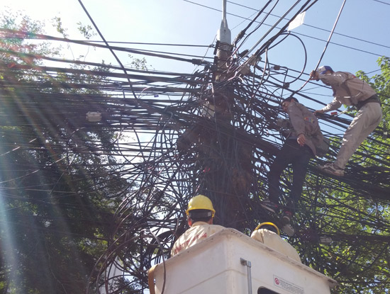 Điện lực Hà Nội đã phát cảnh báo cột điện không đủ sức tải quá nhiều cáp như thế này.