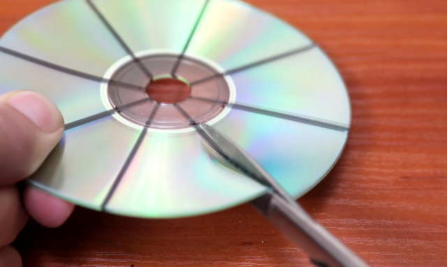  Dùng kéo lần lượt cắt từ ngoài vào đến vòng tròn phía trong của đĩa CD. Và khi đến vòng tròn này, bạn hãy cẩn thận cắt sâu vào thêm 1 chút nữa. 