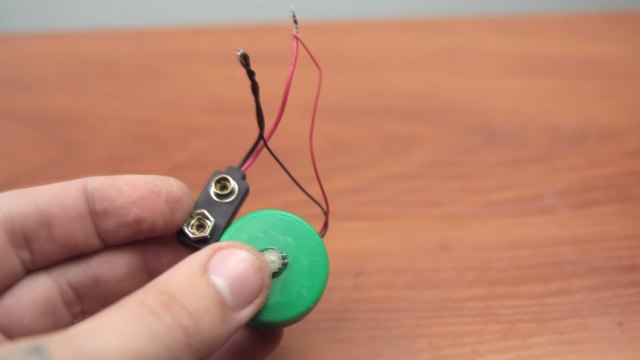  Tiếp theo bạn hãy nối dây điện của mô-tơ với đầu tiếp xúc pin lại với nhau. 