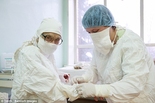  Một đồng nghiệp giúp bà mặc bộ đồ phẫu thuật tại Bệnh viện thành phố Ryazan 