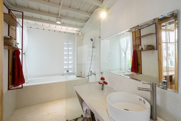  Phòng vệ sinh master bathroom được thiết kế với hệ tắm bồn và ánh sáng tự nhiên. Đồ dùng được đặt trên những kệ thép, cùng vách ngăn bằng kính tạo cảm giác không gian được nới rộng hơn. 