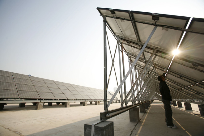  Một công nhân đang làm sạch các tấm pin mặt trời tại nhà máy sản xuất điện từ năng lượng mặt trời, được xây dựng từ ngày 3-11-2008 tại Tây Ninh, tỉnh Thanh Hải, Trung Quốc. 