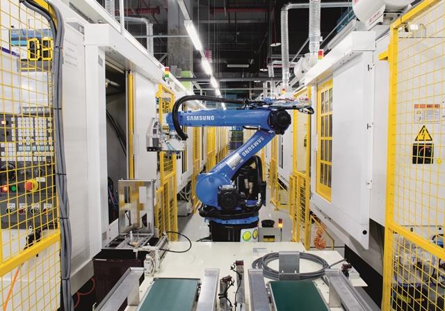 Đây là robot chuyên dụng, giúp chuyển máy vào trong máy cắt cơ khí bằng máy tính (CNC) thay cho công nhân. Trong nhà máy vẫn còn nhiều vị trí do con người đảm nhận nhưng qua quan sát, những chú robot như thế này nhanh hơn nhiều.