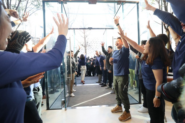  Người tiêu dùng bước vào trong sự đón chào nhiệt liệt từ phía các nhân viên của Apple. 
