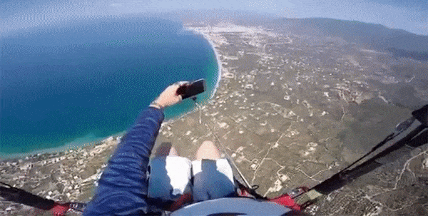 Tiếc thay cho anh chàng đang chụp ảnh selfie trên dù lượn ở độ cao gần 800 mét thì lỡ tay rơi điện thoại - Ảnh 1.