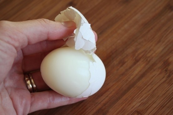Adding a teaspoon of of baking soda when you boil eggs and the shell will come off easily.