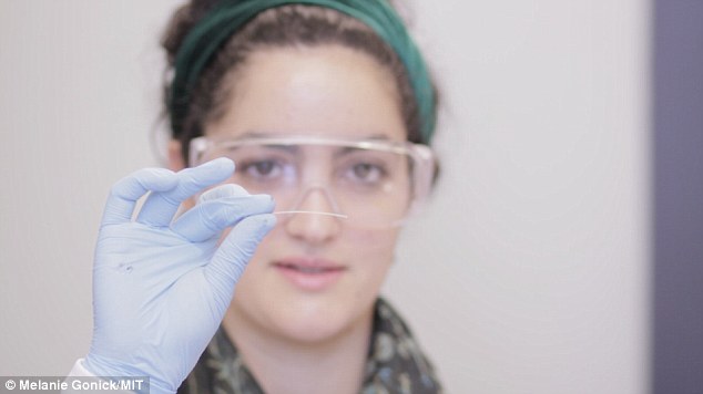 Christina Tringides, a senior at MIT and member of the research team, holds a sample of the multifunction fiber that could deliver optical signals and drugs directly into the brain, along with electrical readouts to continuously monitor the effects of the various inputs.