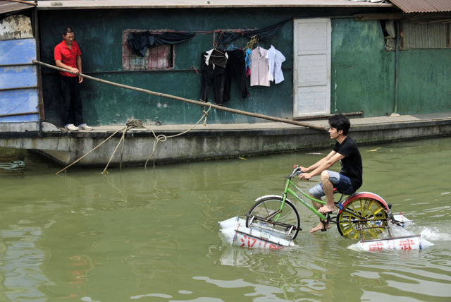 Lei Zhiqian đang đạp xe đạp nổi tự chế trên sông Dương Tử