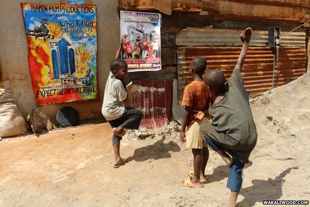  Một nhóm trẻ em làm những động tác kung-fu trước poster quảng cáo phim của Isaac Nabwana 