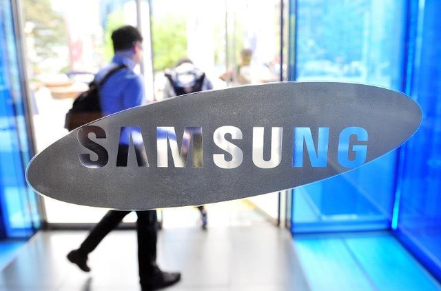 A visitor walks past the Samsung Electronics logo at the companys headquarters in Seoul on April 29, 2014