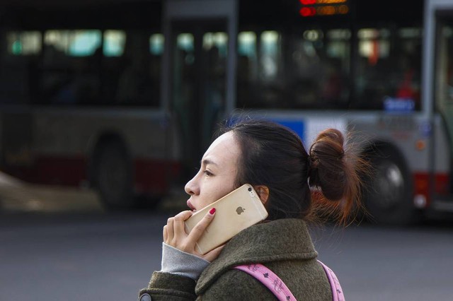 Lợi nhuận của Apple trên điện thoại phản ánh khả năng của mình để có giá cao hơn nhiều. Một phụ nữ ở Bắc Kinh trên iPhone của mình.