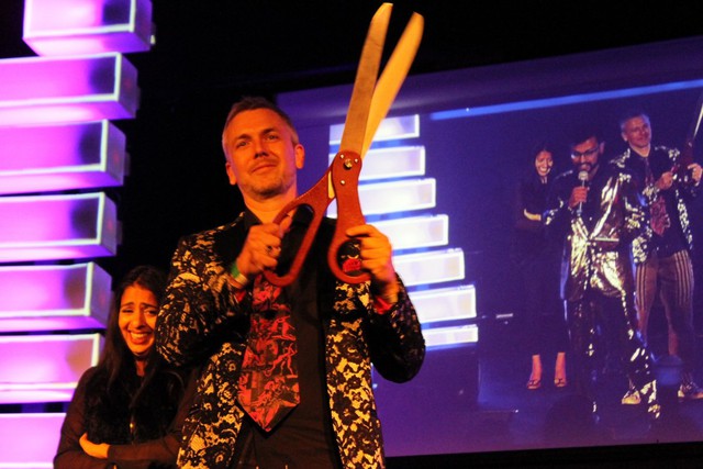 Brady Forrest, VP of PCH, shows off the ribbon-cutting scissors.