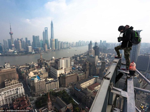 Họ thậm chí còn leo lên một biển quảng cáo lớn để có được những bức ảnh bao quát về cảng biển Thượng Hải và những tòa nhà trọc trời ở phía xa.