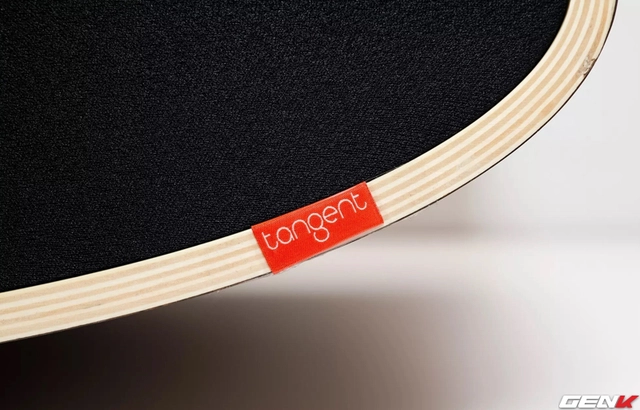 Logo Tangent Audio màu đỏ nổi bật trên viền loa, cùng với mặt cắt phía trước của loa, chúng ta có thể nhìn thấy các vân gỗ đẹp mắt.