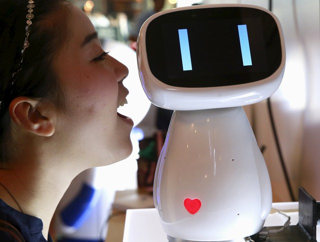  Một du khách đang nói chuyện với robot Xiaodu của Baidu tại Hội nghị Thế giới Baidu 2015 ở Bắc Kinh, Trung Quốc. Xiaodu là mẫu robot AI có khả năng truy cập vào cơ sở dữ liệu tìm kiếm của Baidu để phản hồi bằng giọng nói. Ảnh Tân Hoa Xã. 