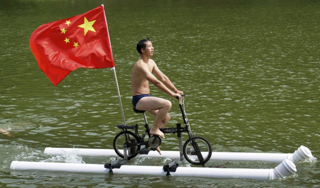  6. Thanh niên Liu Wanyong ở quận Zhenning, tỉnh Quý Châu đã tạo ra phiên bản cải tiến mới của xe đạp, có khả năng chạy trên mặt nước nhờ vào hai ống nước lớn giúp nó có thể nổi được. 