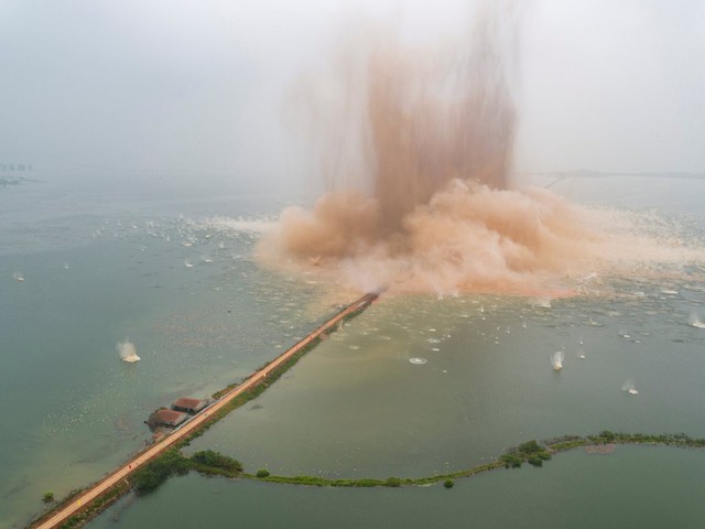  Đê ngăn cách hai hồ nước ở Vũ Hán, Trung Quốc, đang bị thổi tung một cách ngoạn mục. 