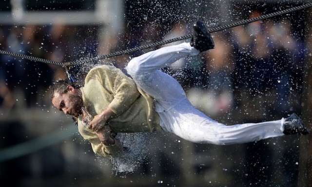 Người đ&agrave;n &ocirc;ng đang cố k&eacute;o đứt cổ con ngỗng chết trong lễ hội Antzar Eguna (ng&agrave;y của những ch&uacute; ngỗng) ở thị trấn Basque, Lekeitio, gần Bilbao, T&acirc;y Ban Nha. Ảnh chụp ng&agrave;y 5/9/2013. Trong lễ hội n&agrave;y, những ch&uacute; ngỗng sẽ trị treo tr&ecirc;n sợi d&acirc;y, c&ograve;n những người đ&agrave;n &ocirc;ng được chở tr&ecirc;n con thuyền b&ecirc;n dưới cố gắng nhảy l&ecirc;n k&eacute;o để k&eacute;o đứt cổ ch&uacute;ng.