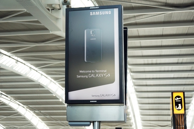 Những tấm biển quảng cáo có thể thấy rải rác ở sân bay, màn hình của Samsung đang hiển thị quảng cáo về Galaxy S5.
