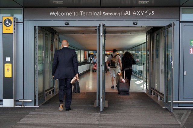 Bảng chào đón khách với chữ &quot;Chào mừng tới Nhà ga T5&quot; vẫn còn in mờ bên dưới chữ Samsung Galaxy S5