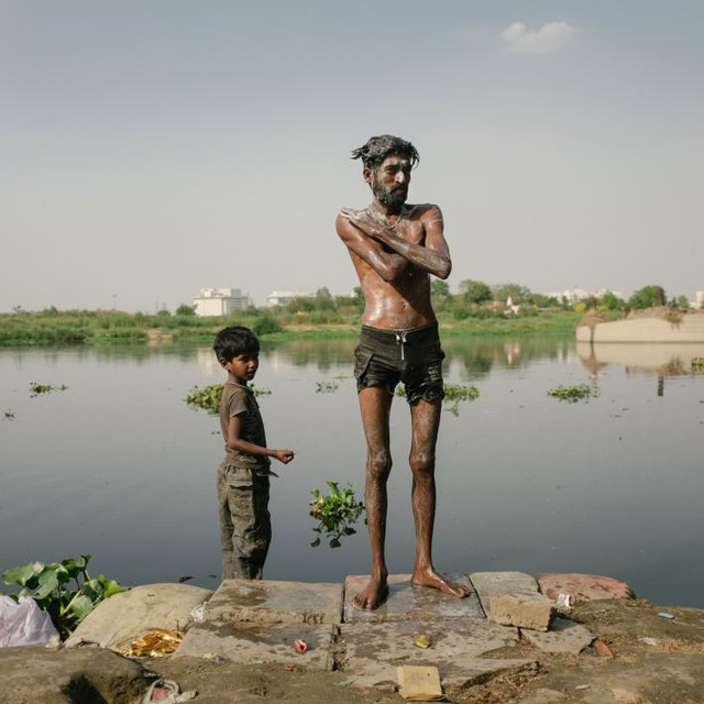  Hai cha con đang tắm trên sông Yamuna. Vì quá ô nhiễm nên chính quyền đã cấm người dân cho gia súc tắm dưới sông. 