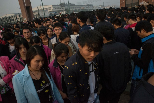  Công nhân ca tối đi vào và công nhân ca trước đó tan làm ở nhà máy Foxconn. 