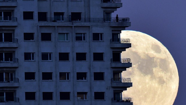  Siêu trăng tại thành phố Madrid, với bóng một người đàn ông đang từ lan can trông về phía xa. Ảnh AFP/Getty Image. 