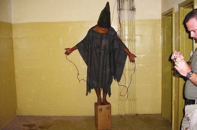  Trong cuộc chiến tại Iraq bắt đầu từ năm 2003, cảnh sát và CIA Mỹ đã tiến hành nhiều biện pháp tra tấn tù nhân tại nhà tù Abu Ghraib, Iraq. Các hình thức tra tấn bao gồm đánh đập, hãm hiếp, tra tấn tinh thần và cả giết người. Phải mãi tới năm 2004, khi những bức hình được công bố, người ta mới biết quy mô của nó ra sao. Trong bức hình là một người bị gắn dây điện. Nếu anh ta rơi xuống khỏi cái hộp thì sẽ bị chích điện tới chết. 