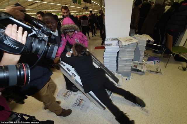  Một phụ nữ cố gắng nằm đè lên chiếc ti vi sau khi cãi nhau tranh giành chiếc ti vi này với những khách hàng khác tại 1 cửa hàng Asda ở Wembley. 