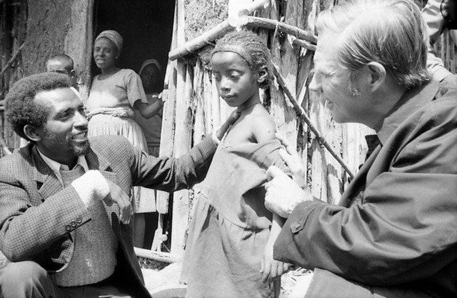  Bác sĩ Henderson kiểm tra vết sẹo tiêm chủng trên tay một cô bé Ethiopia 