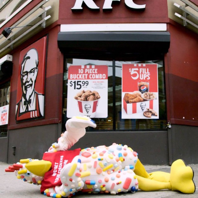  Một chú gà linh vật Auntie Biotic nằm trước cửa hàng của KFC 