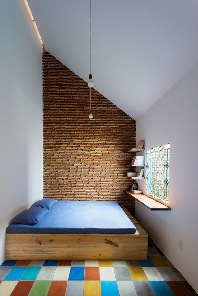  Không gian ngủ được thiết kế tối giản với gường, những đợt gỗ được gắn làm bàn đọc sách, cạnh đó là khoảng thông tầng 