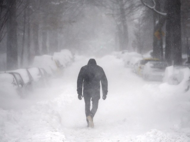  Một người đàn ông đi bộ trong một cơn bão tuyết ở Washington. 