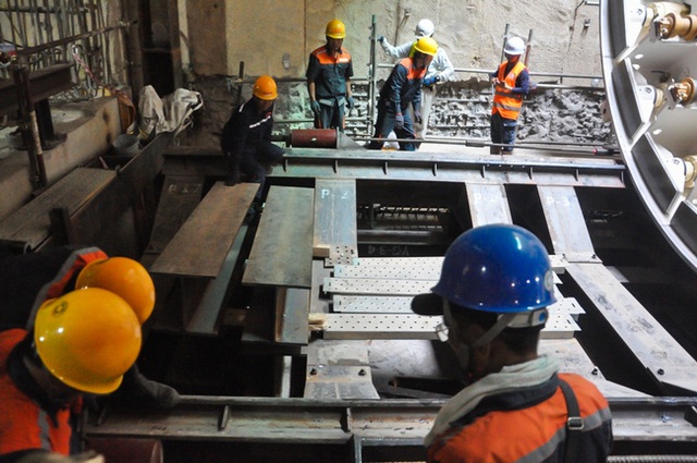 Hàng chục kỹ sư và công nhân xây dựng tại công trình nhà ga ngầm đang tiến hành lắp đặt robot TBM.