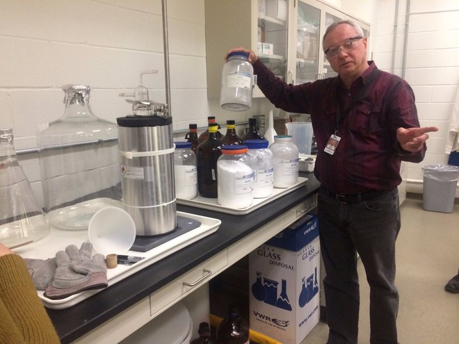 Một nhà khoa học đang cầm chiếc bình rỗng vốn được dùng để đựng nguyên liệu dùng cho các thí nghiệm của mình. 