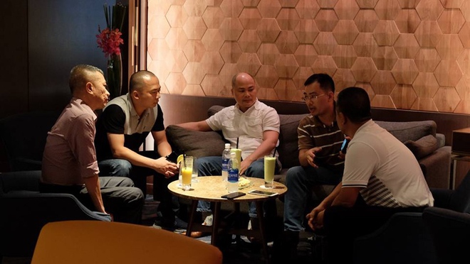 Ông Đoàn Văn Hiểu Em (thứ hai từ trái qua) cùng ông Nguyễn Tử Quảng (ngồi chính giữa) đang theo dõi thiết bị dường như là Bphone - Ảnh: FB H.E