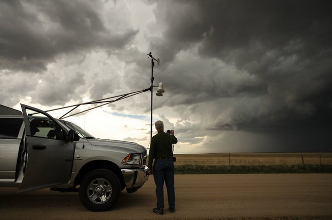  Cựu chiến binh, thợ săn bão 40 tuổi, Tim Marshall, đang chụp ảnh một đám mây nhỏ được hình thành từ một cơn bão Supercell trong một nhiệm vụ nghiên cứu cơn lốc xoáy ở hạt Elbert, bang Colorado, ngày 8 tháng 5 năm 2017. Ông đứng bên cạnh chiếc xe thám hiểm cùng với các dụng cụ đo lường thời tiết được gắn phía trước. 