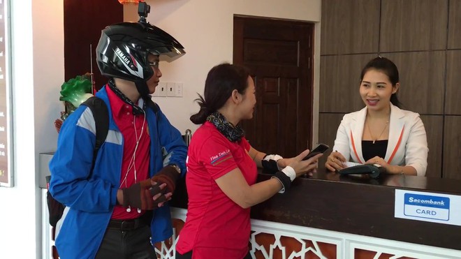  Anh Thịnh và chị Huyền đang chia sẻ với một nhân viên khách sạn về sự tiện dụng, thuận lợi của Samsung Pay 
