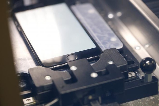  Cận cảnh một chiếc iPhone nằm trong máy sửa chữa. 