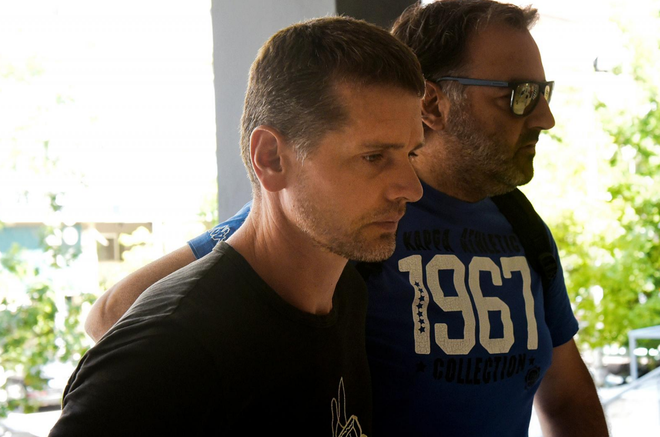  Nghi phạm Alexander Vinnik (bên trái) bị cảnh sát mặc thường phục áp giải tới một phiên tòa ở Hy Lạp ngày 26/7/2017. 