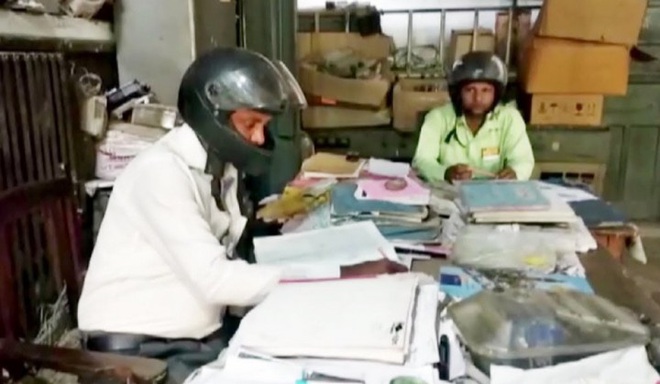 Chuyện khôi hài: Nhân viên văn phòng Ấn Độ đội mũ bảo hiểm trong lúc làm việc để tránh bị mái nhà rơi xuống đầu - Ảnh 1.